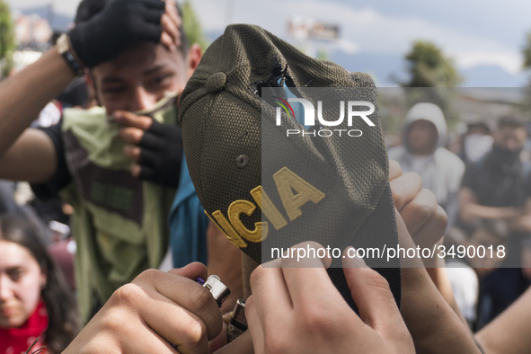 People who participate in the march of students for public education in Bogota, Colombia, on 28 November 2018. burn a cap of a police office...