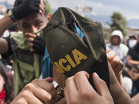 People who participate in the march of students for public education in Bogota, Colombia, on 28 November 2018. burn a cap of a police office...