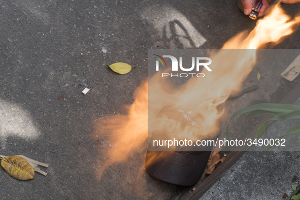 People who participate in the march of students for public education in Bogota, Colombia, on 28 November 2018. burn a cap of a police office...