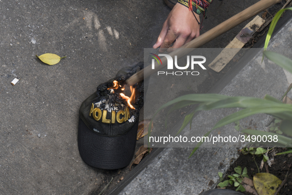 People who participate in the march of students for public education in Bogota, Colombia, on 28 November 2018. burn a cap of a police office...