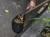 People who participate in the march of students for public education in Bogota, Colombia, on 28 November 2018. burn a cap of a police office...