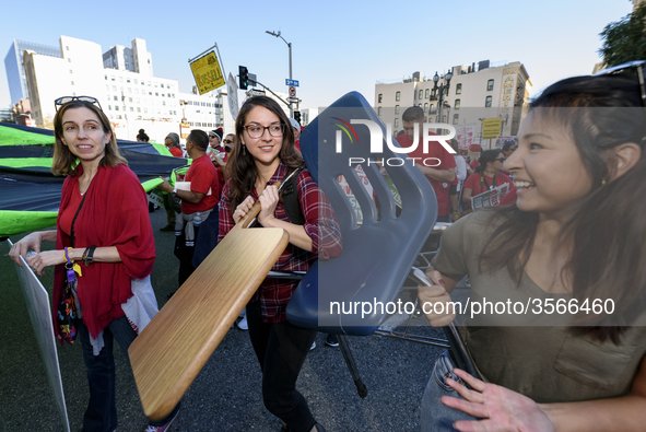 Supporters of public education carry a school desk and chair during the March for Public Education in Los Angeles, California on December 15...