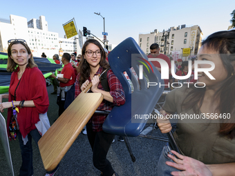 Supporters of public education carry a school desk and chair during the March for Public Education in Los Angeles, California on December 15...