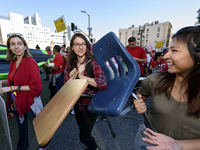 Supporters of public education carry a school desk and chair during the March for Public Education in Los Angeles, California on December 15...