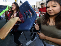 Supporters of public education carry a school desk and chair during the March for Public Education in Los Angeles, California on December 15...