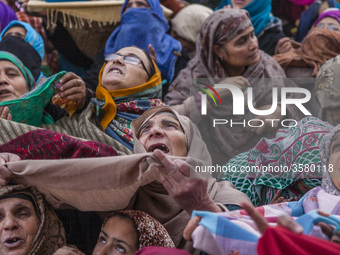 Kashmiri Muslim women devotees look towards a cleric (not seen in the picture) displaying the holy relic believed to be the whisker from the...