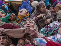 Kashmiri Muslim women devotees look towards a cleric (not seen in the picture) displaying the holy relic believed to be the whisker from the...