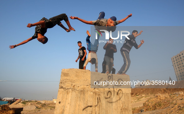 Palestinian youths practice parkour by the beach at sunset in Gaza City on City January 7, 2018. 