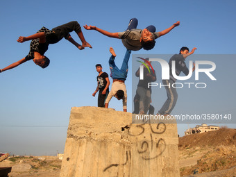 Palestinian youths practice parkour by the beach at sunset in Gaza City on City January 7, 2018. (