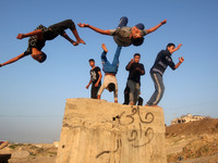 Palestinian youths practice parkour by the beach at sunset in Gaza City on City January 7, 2018. (