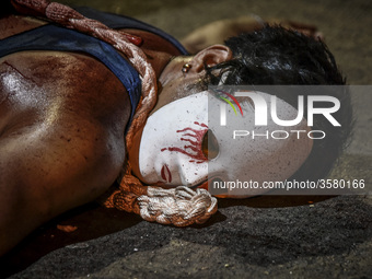 A masked flagellant lies on the ground during Good Friday Lenten rites in Navotas, Metro Manila, Philippines, March 30, 2018.

Photo: Ezra A...