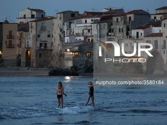 Children play with a ball on the waterfront at sunset in Cefalu. Sicily, Italy, Saturday, May 5, 2018
 (