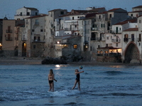 Children play with a ball on the waterfront at sunset in Cefalu. Sicily, Italy, Saturday, May 5, 2018
 (