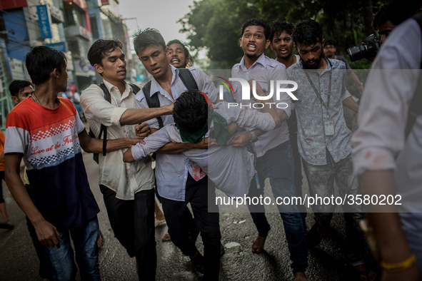 Students help an injured man as pro-government activists threw stones and attacked them violently, in Dhaka, Bangladesh, on August 4, 2018. 