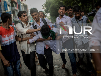 Students help an injured man as pro-government activists threw stones and attacked them violently, in Dhaka, Bangladesh, on August 4, 2018....