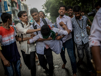 Students help an injured man as pro-government activists threw stones and attacked them violently, in Dhaka, Bangladesh, on August 4, 2018....