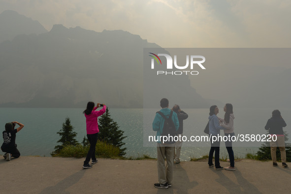 A group of tourists takes pictures of Bow Lake in the Rocky Mountains, during smoky and hazy weather conditions that blanketed the province...