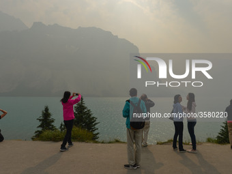 A group of tourists takes pictures of Bow Lake in the Rocky Mountains, during smoky and hazy weather conditions that blanketed the province...