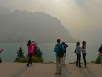 A group of tourists takes pictures of Bow Lake in the Rocky Mountains, during smoky and hazy weather conditions that blanketed the province...