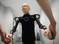 In this photo taken on September 13, 2018 shows the hand of child android robot called &quot;Ibuki&quot; with his creator during demonstrati...