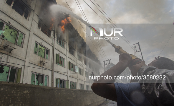 Fire fighters and volunteers try to douse flames after fire breaks out at Pamposh hotel  on September 15, 2018 in  Srinagar, the summer capi...