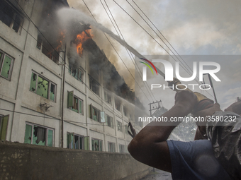 Fire fighters and volunteers try to douse flames after fire breaks out at Pamposh hotel  on September 15, 2018 in  Srinagar, the summer capi...