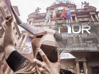 Activist against animal cruelty in bull fightings  wears a paperboard bullhead mask under the Pamplona city council building, Spain before t...