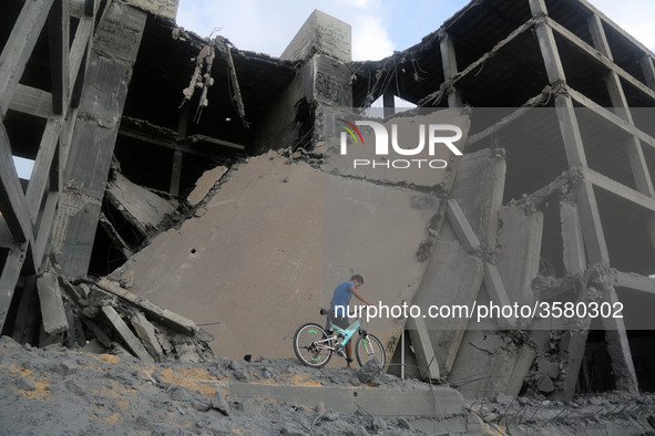 Palestinians walk through the wreckage of a building that was damaged by Israeli air strikes in Gaza City on July 15, 2018. Israel's militar...