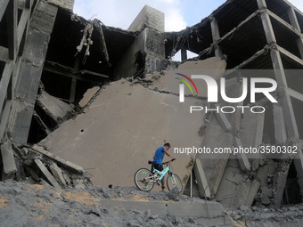 Palestinians walk through the wreckage of a building that was damaged by Israeli air strikes in Gaza City on July 15, 2018. Israel's militar...