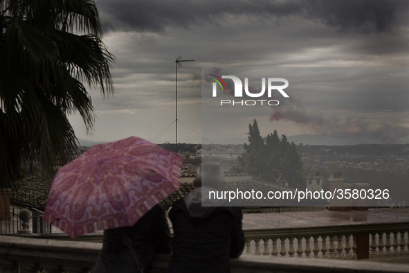 A couple watches smoke with the colors of the Italian flag  left by Air Force aerobatic unit Frecce Tricolori (Tricolor Arrows) over Rome on...