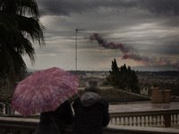 A couple watches smoke with the colors of the Italian flag  left by Air Force aerobatic unit Frecce Tricolori (Tricolor Arrows) over Rome on...