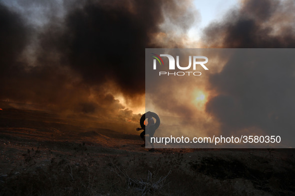 Palestinian protesters set tyres on fire at the Israel-Gaza border east of Gaza city, on October 12, 2018. 