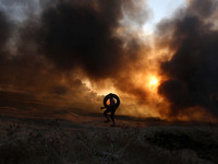 Palestinian protesters set tyres on fire at the Israel-Gaza border east of Gaza city, on October 12, 2018. (