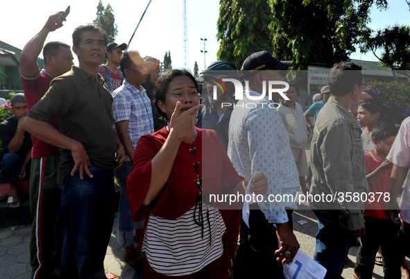 Palu residents search for families in the ruins of a house that collapsed in the recent earthquake and tsunami, near Talise Beach in Palu, C...