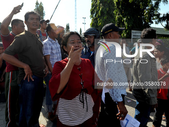 Palu residents search for families in the ruins of a house that collapsed in the recent earthquake and tsunami, near Talise Beach in Palu, C...