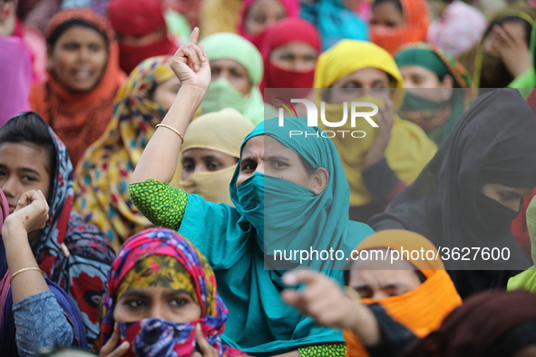 Bangladeshi garment workers shout slogans as they block a road during a demonstration to demand higher wages, in Dhaka on January 9, 2019.  