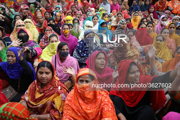 Bangladeshi garment workers shout slogans as they block a road during a demonstration to demand higher wages, in Dhaka on January 9, 2019.  