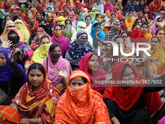 Bangladeshi garment workers shout slogans as they block a road during a demonstration to demand higher wages, in Dhaka on January 9, 2019....