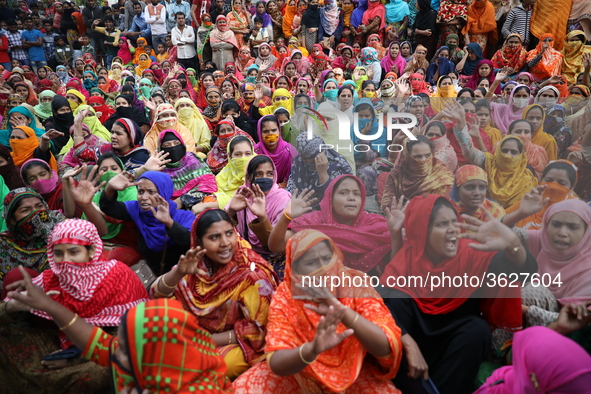 Bangladeshi garment workers shout slogans as they block a road during a demonstration to demand higher wages, in Dhaka on January 9, 2019.  