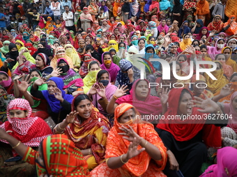 Bangladeshi garment workers shout slogans as they block a road during a demonstration to demand higher wages, in Dhaka on January 9, 2019....