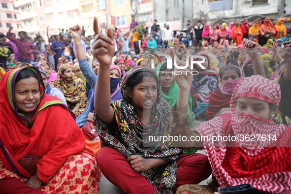 Bangladeshi garment workers shout slogans as they block a road during a demonstration to demand higher wages, in Dhaka on January 9, 2019.  