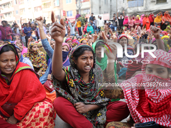 Bangladeshi garment workers shout slogans as they block a road during a demonstration to demand higher wages, in Dhaka on January 9, 2019....