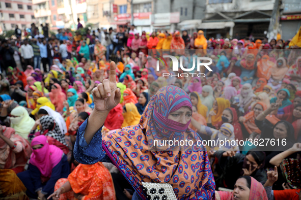 Bangladeshi garment workers shout slogans as they block a road during a demonstration to demand higher wages, in Dhaka on January 9, 2019.  