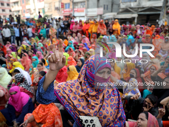 Bangladeshi garment workers shout slogans as they block a road during a demonstration to demand higher wages, in Dhaka on January 9, 2019....