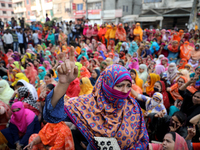 Bangladeshi garment workers shout slogans as they block a road during a demonstration to demand higher wages, in Dhaka on January 9, 2019....