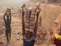 A man stacks more than a dozen bricks on his head while working at in brickfields Narayanganj near Dhaka Bangladesh on January 12, 2019. (