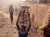 A man stacks more than a dozen bricks on his head while working at in brickfields Narayanganj near Dhaka Bangladesh on January 12, 2019. (