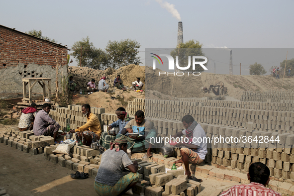 Brick field workers are eating lunch after his work shift in brickfields Narayanganj near Dhaka Bangladesh on January 12, 2019 