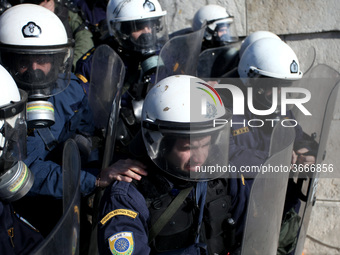 Riot police officer without tear gas mask while spraying protesters during a protest outside the Greek Parliament in Athens, Greece on Janua...