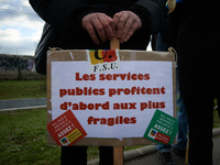 A man holds a placard reading 'Public services are first good for the most precarious'. Several schoolteachers unions and two students union...